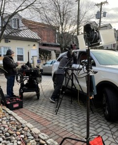 Video crew filming an outdoor scene in an SUV